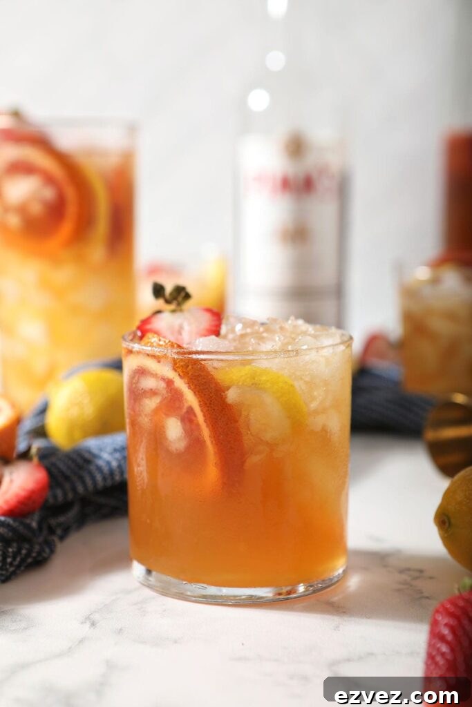 Pimm’s Punch Recipe: Classic Summer Cocktail Guide 2 A glass of a Pimms drink garnished with blood orange, lemon and strawberry