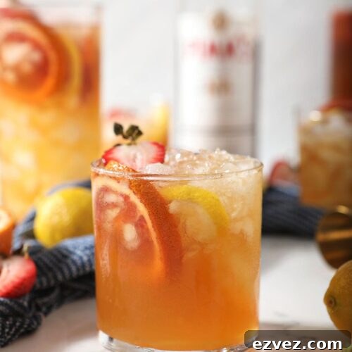 Pimm’s Punch Recipe: Classic Summer Cocktail Guide 8 A glass of a Pimms drink garnished with blood orange, lemon and strawberry