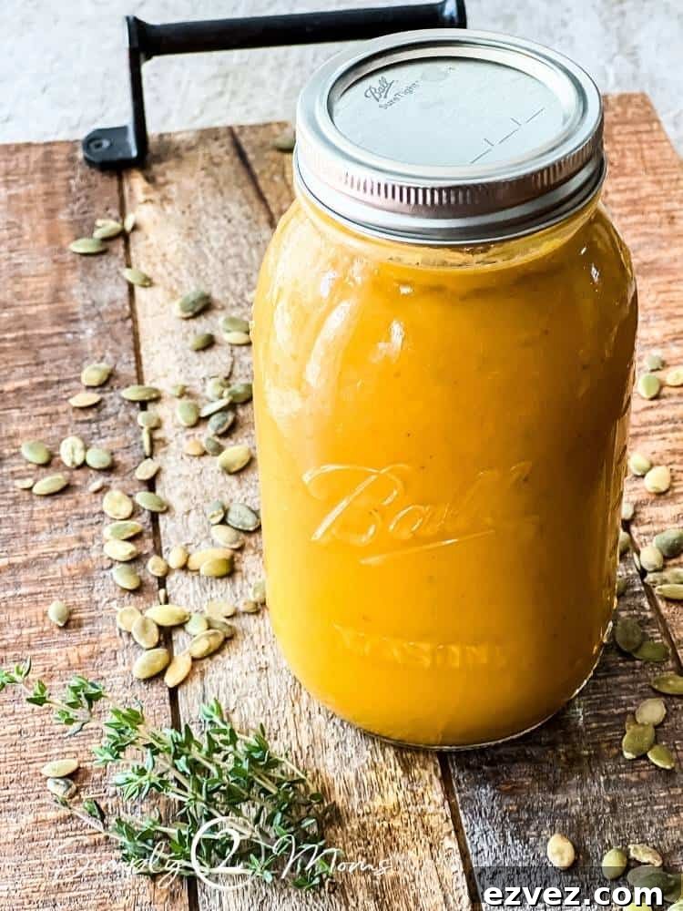 1 quart mason jar filled with butternut squash soup on a wood board