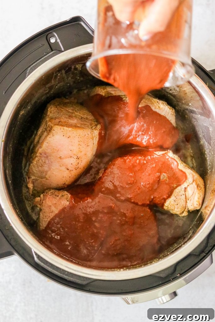 Covering pork shoulder with paleo mole sauce in the Instant Pot