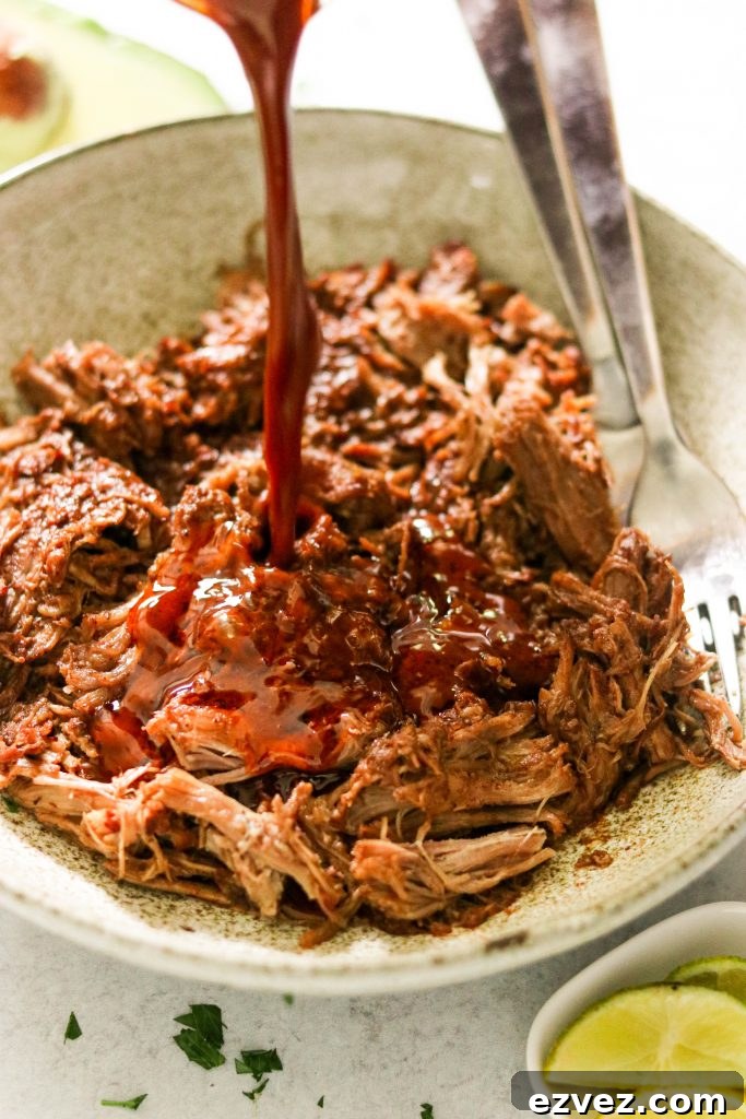 pouring mole sauce over Whole30 pulled pork