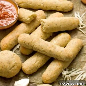 A stack of gluten-free Olive Garden copycat breadsticks on a sheet of parchment paper.