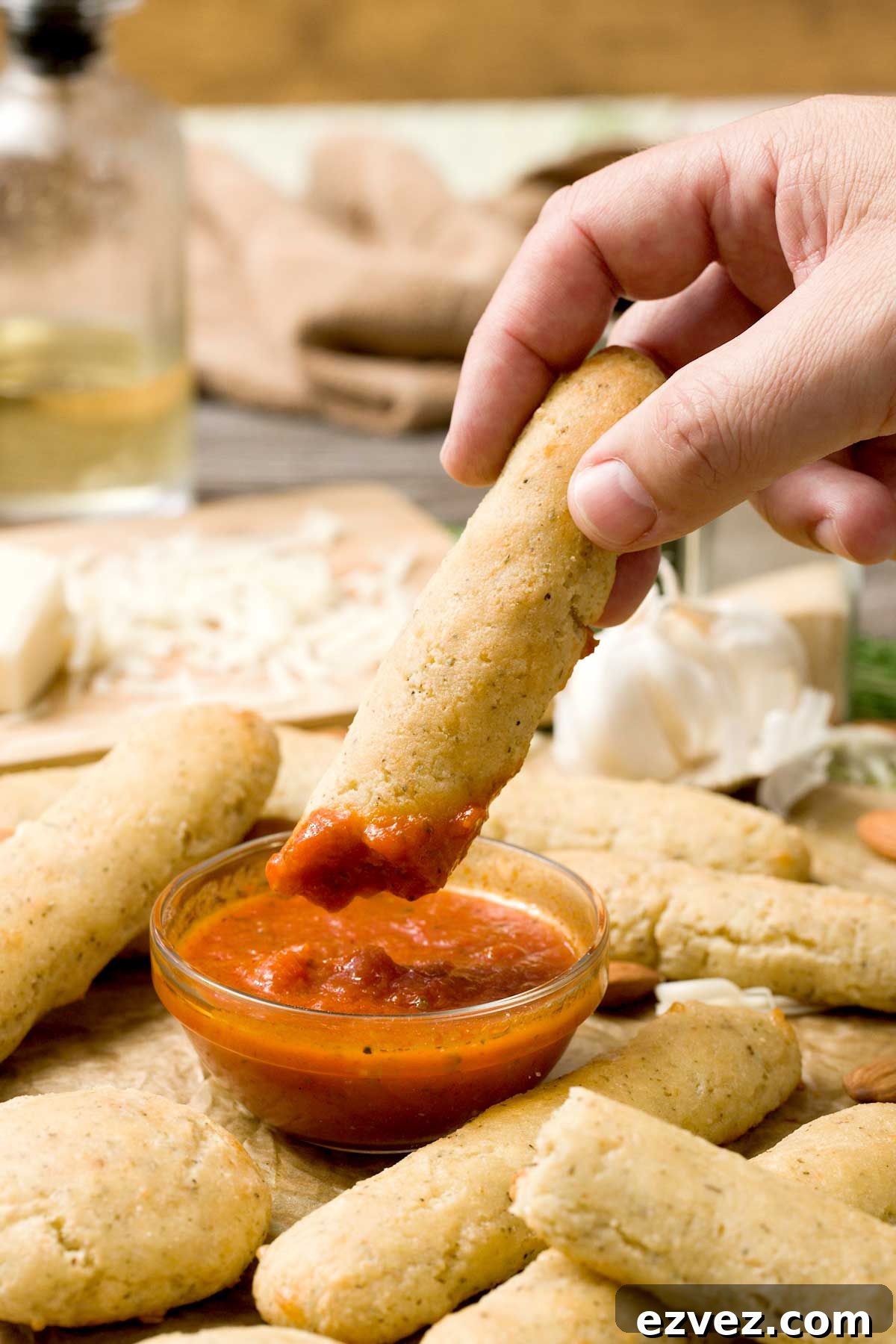 Dipping an almond flour bread stick into a bowl of marinara sauce.