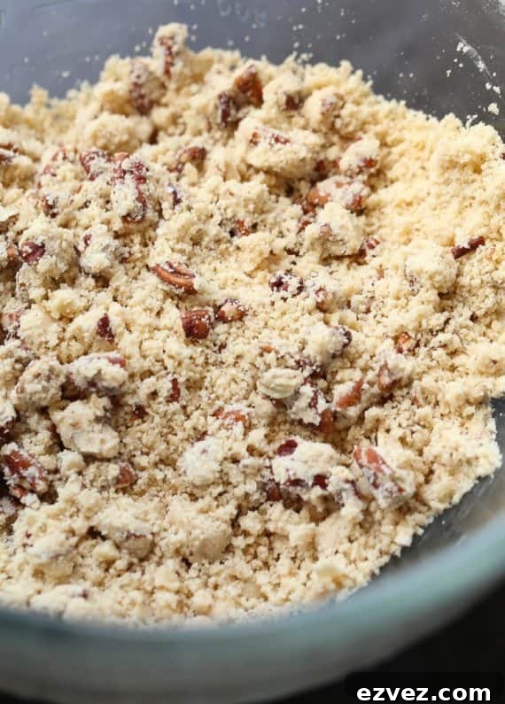 Flour, butter, pecans, and brown sugar mixed in a bowl to make a praline crumble.