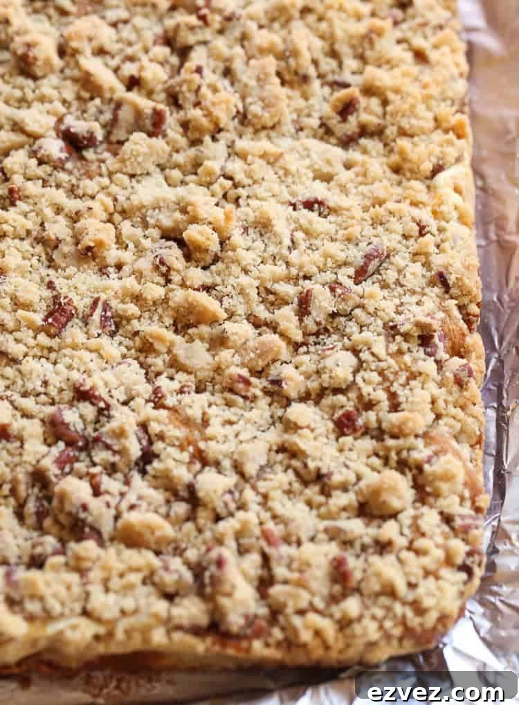 Overhead view of a baking dish full of uncut pumpkin cheesecake bars topped with a praline.