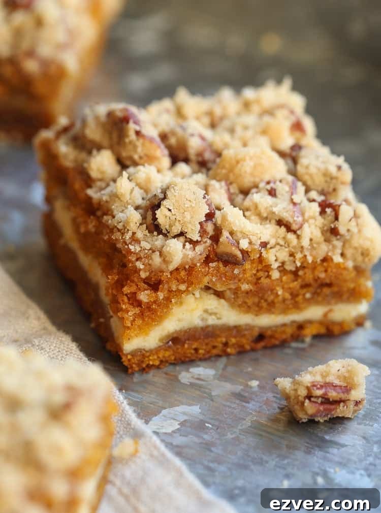 Close up of a pumpkin cheesecake bar topped with pecan praline.