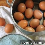 A dozen fresh hard boiled eggs in a stainless steel pot