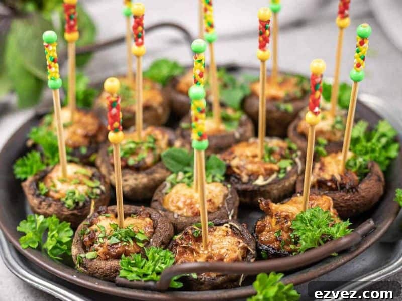 11 Party Appetizers Guests Devour Immediately 12 A platter of stuffed mushrooms garnished with parsley, each topped with cheese and served with colorful appetizer picks.