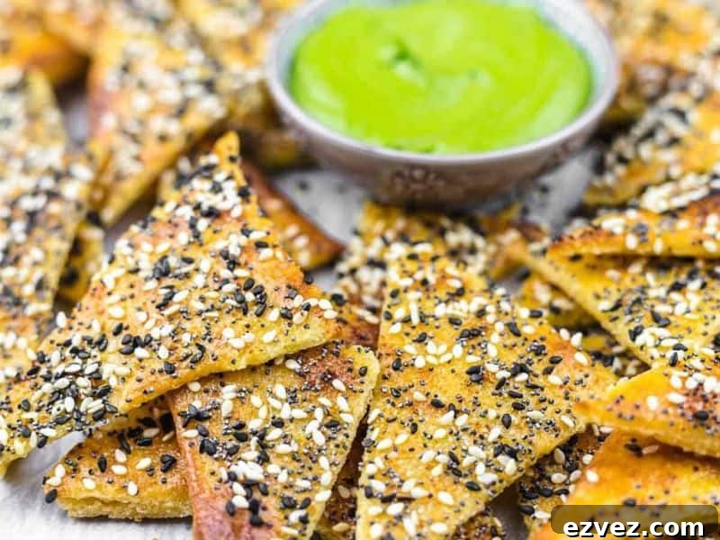 11 Party Appetizers Guests Devour Immediately 10 Triangle chips topped with mixed seeds are arranged around a bowl of green dipping sauce.