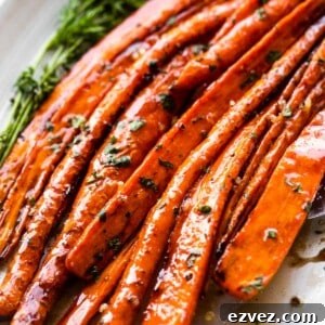 close up shot of air fryer cooked carrots arranged on a long oval platter and drizzled with balsamic glaze.