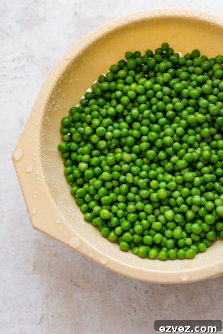 Frozen peas thawing in a colander