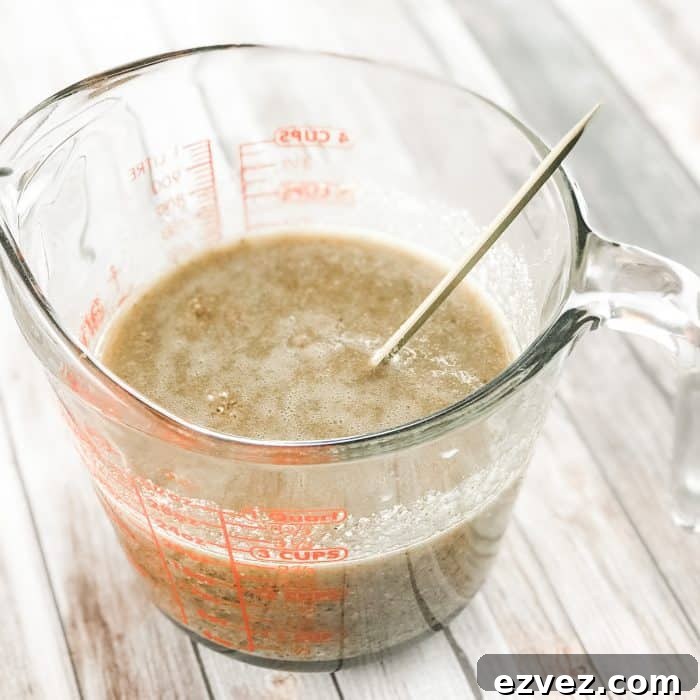 stirring in ground rice, almonds, and beans to melted cocoa butter and shea butter and lemon and lavender essential oils to make homemade Lush Buffy Bar with essential oils