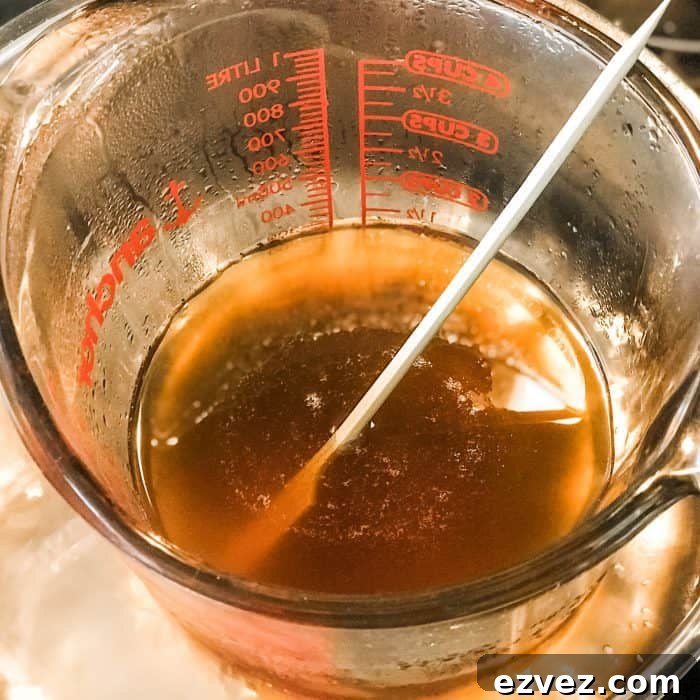 melted cocoa butter and shea butter in glass jar on top of saucepan with water, for use in Lush Buffy Bar