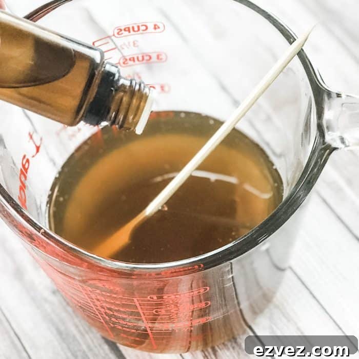 adding lemon and lavender essential oils to melted cocoa butter and shea butter, making DIY Lush Buffy Bar with essential oils