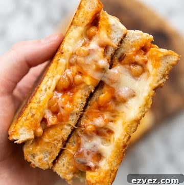 overhead shot of open sandwich showing cheesy beans above marble background
