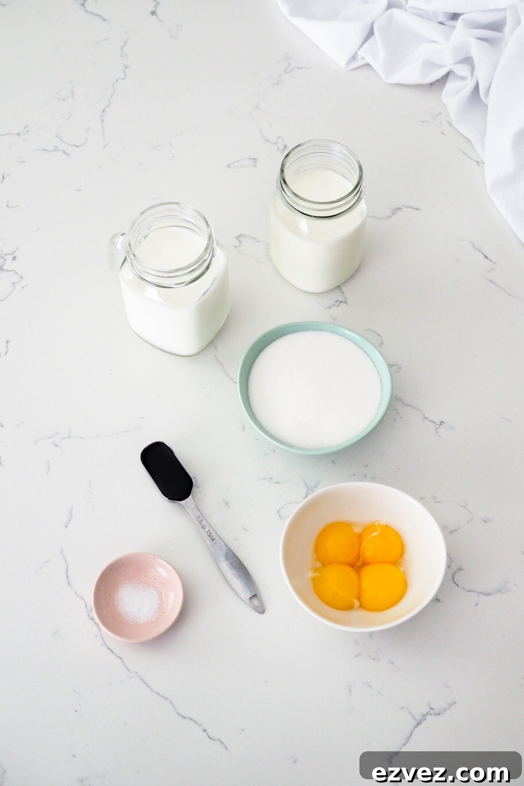 Ingredients for French vanilla ice cream on a white counter.