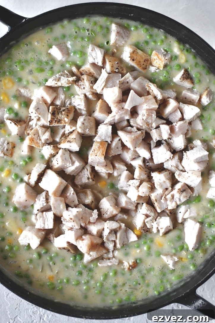 Adding the chicken to the sauce.