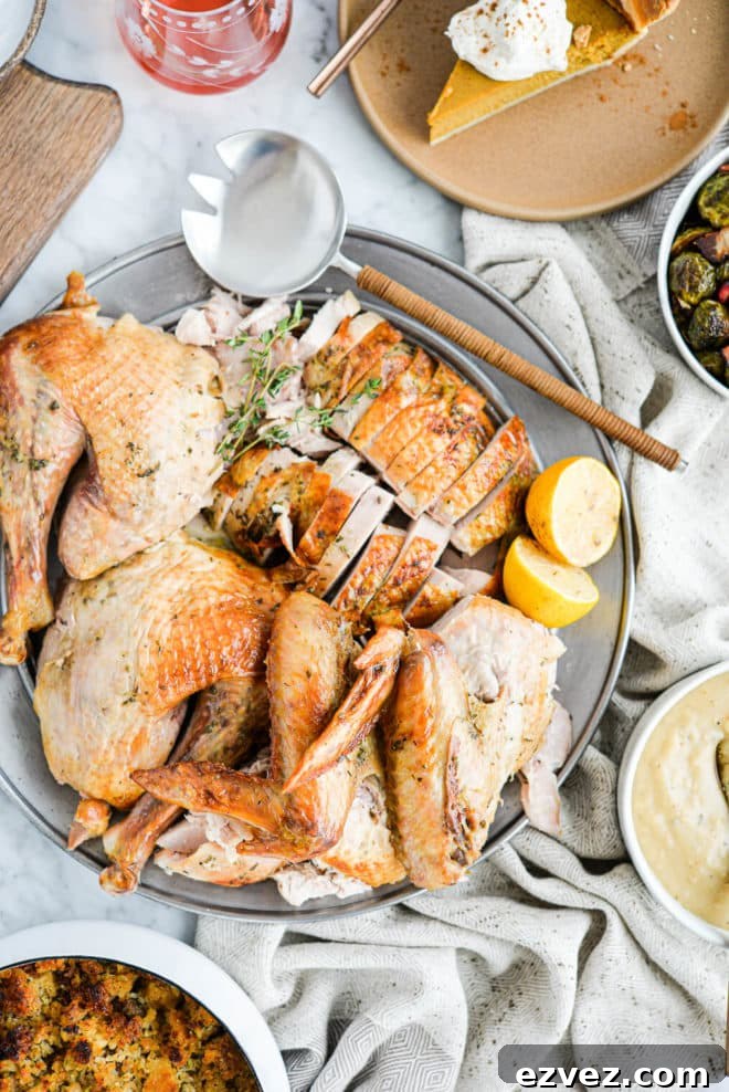 top view of a carved whole turkey sitting in the center of a thanksgiving spread