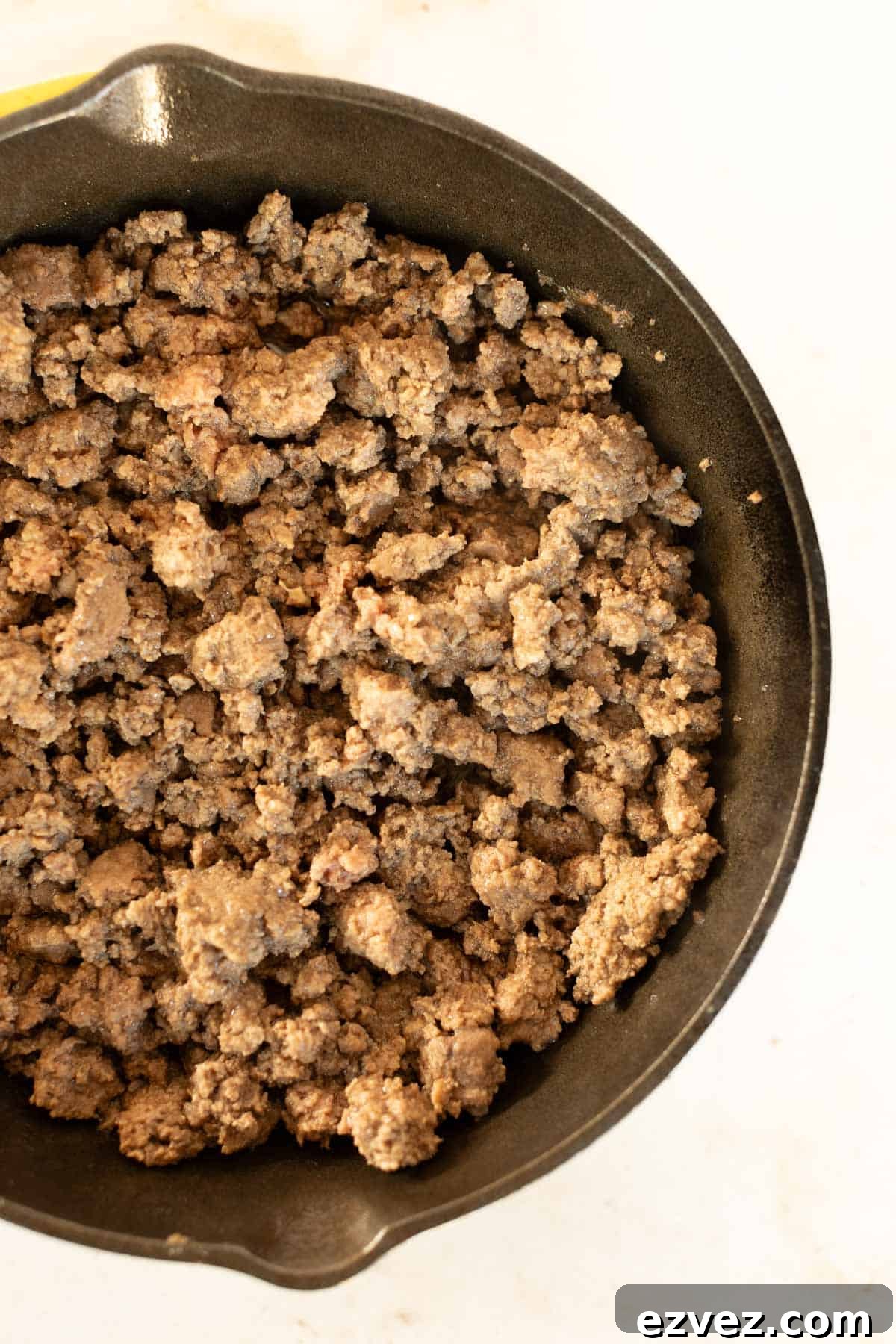 A skillet with ground beef in it.