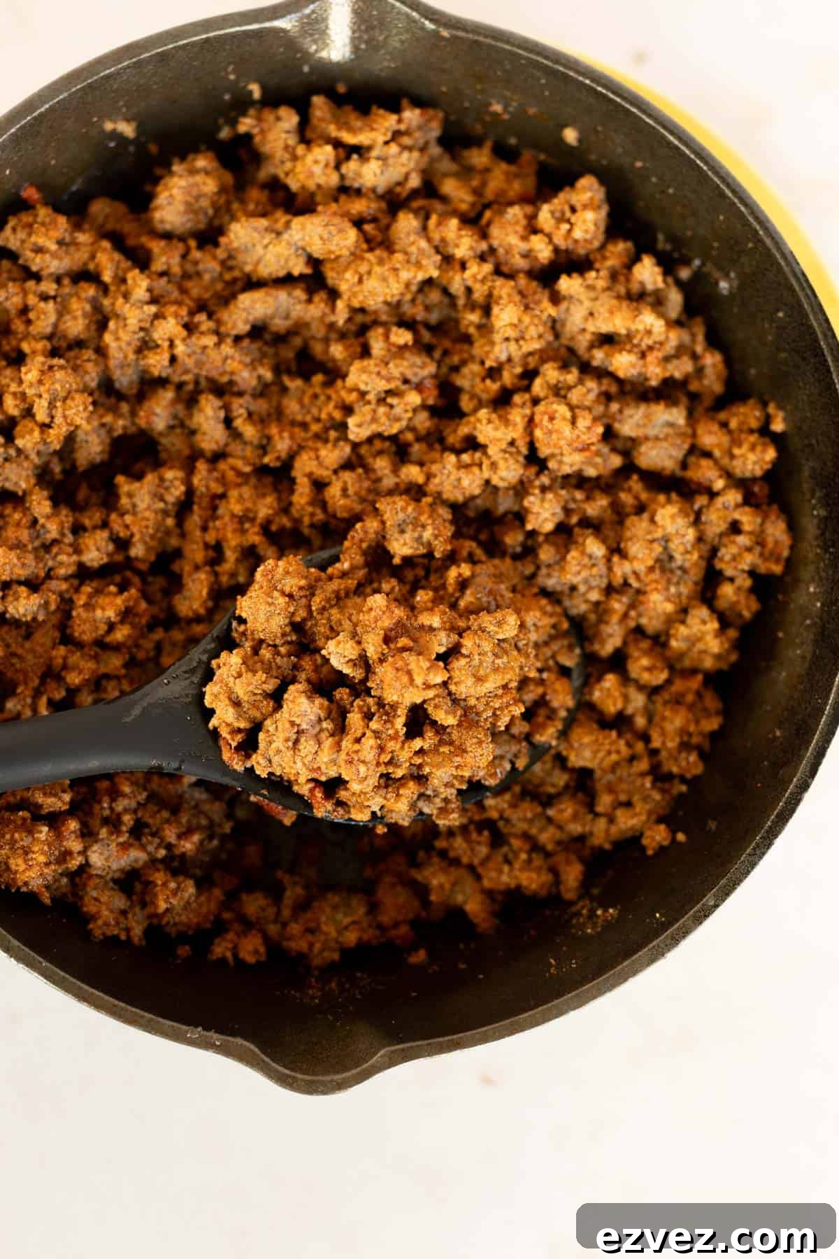 A bowl of easy taco meat with a spoon.