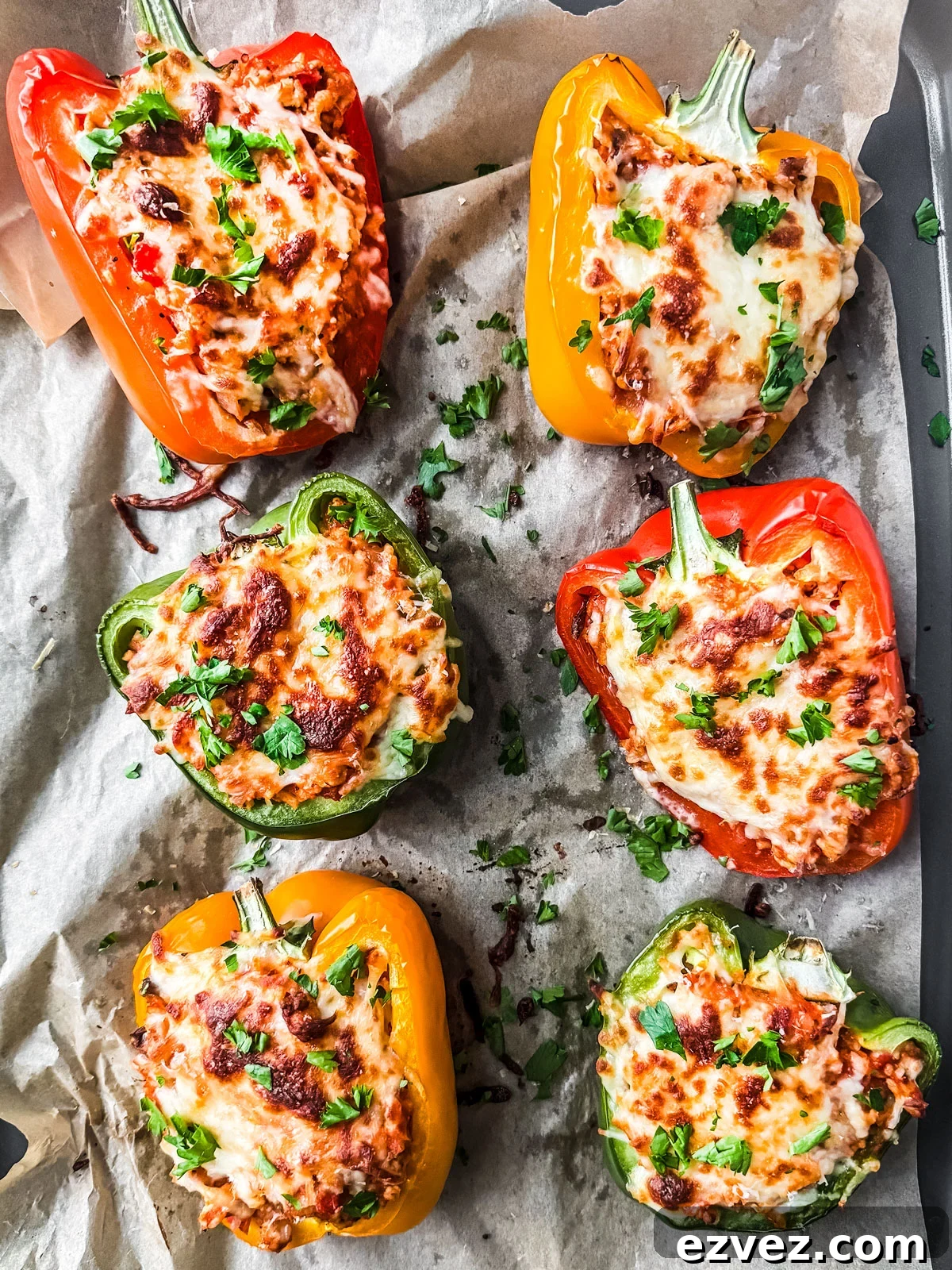 Turkey-Stuffed Bell Peppers with Savory Rice Filling 2 Baked cheesy stuffed peppers with ground turkey garnished with fresh parsley.