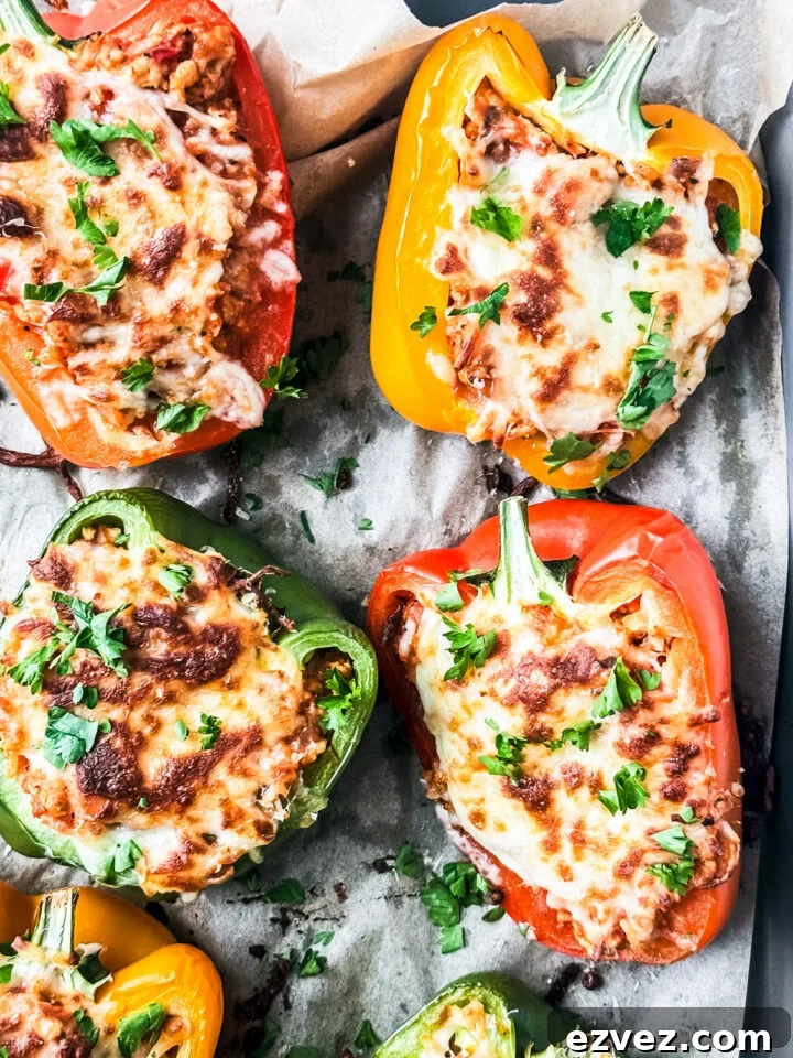 Turkey-Stuffed Bell Peppers with Savory Rice Filling 9 Baked cheesy stuffed peppers with ground turkey on a baking sheet.