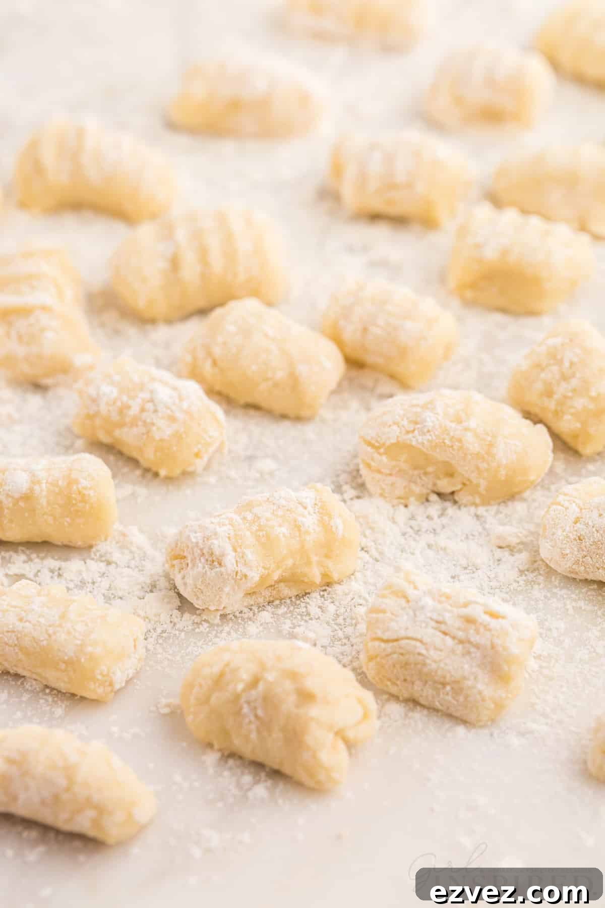 Homemade potato gnocchi on a sheet of parchment paper.