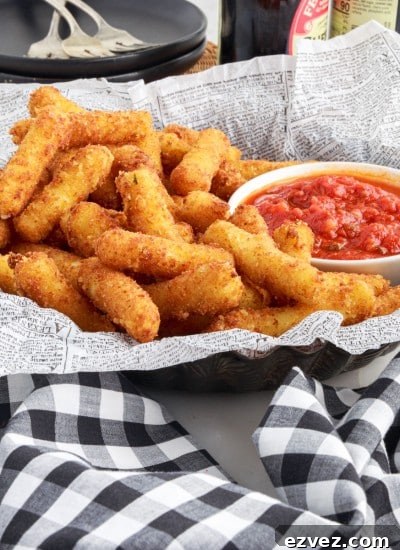 lined dish of stuffed ziti fritta with sauce, black and white checked napkins in front