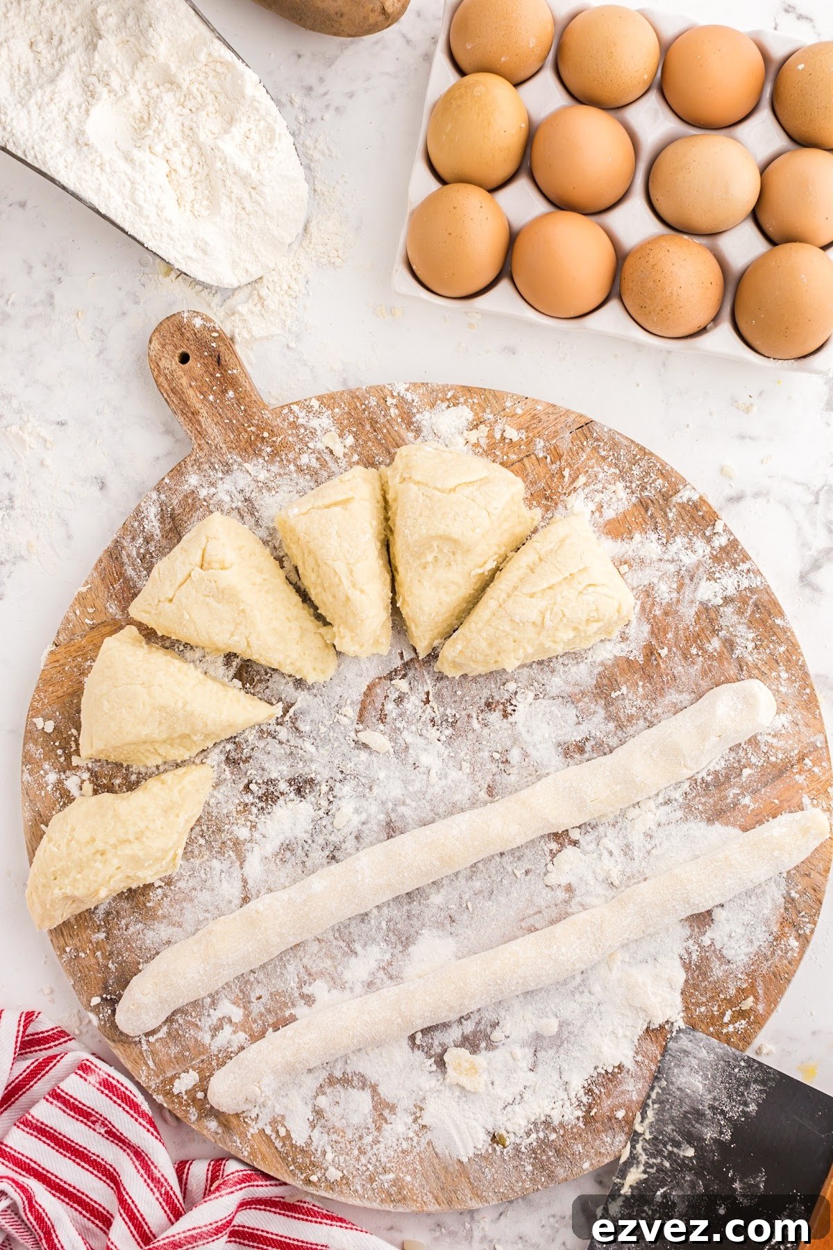 Rolling the dough pieces into long strips.