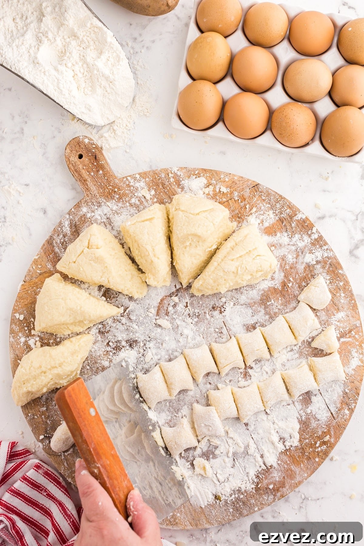 Cutting the strips of dough into bite sized pieces.