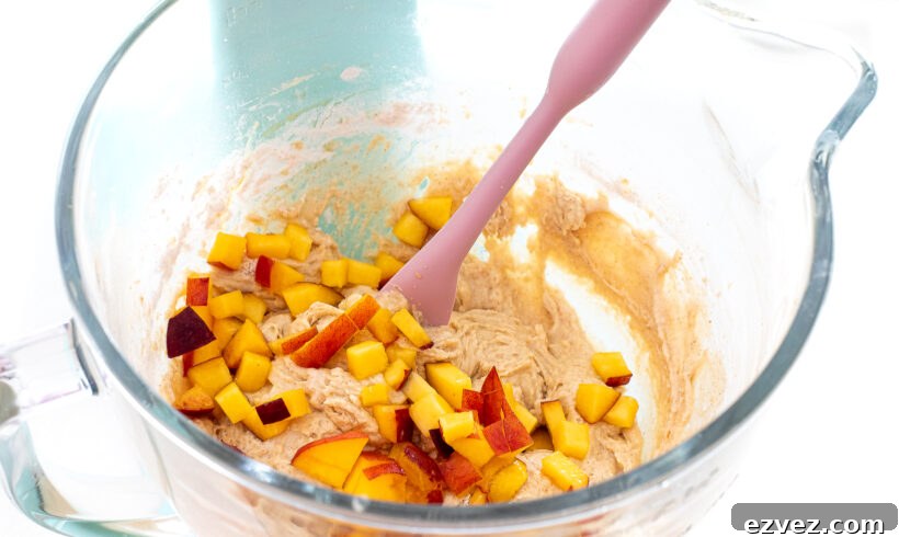 adding diced peaches to cake batter