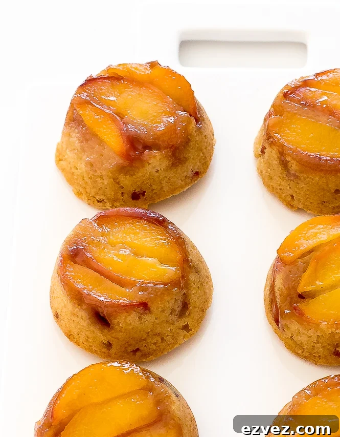 Mini Peach Upside Down Cakes on a white chopping board.