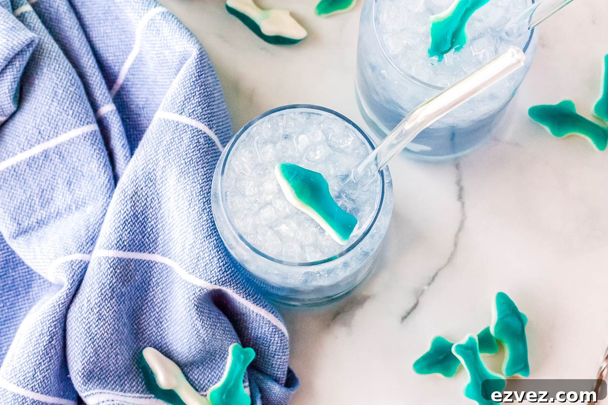 Two Swig shark attack drinks are on a counter, and gummy sharks surround them.