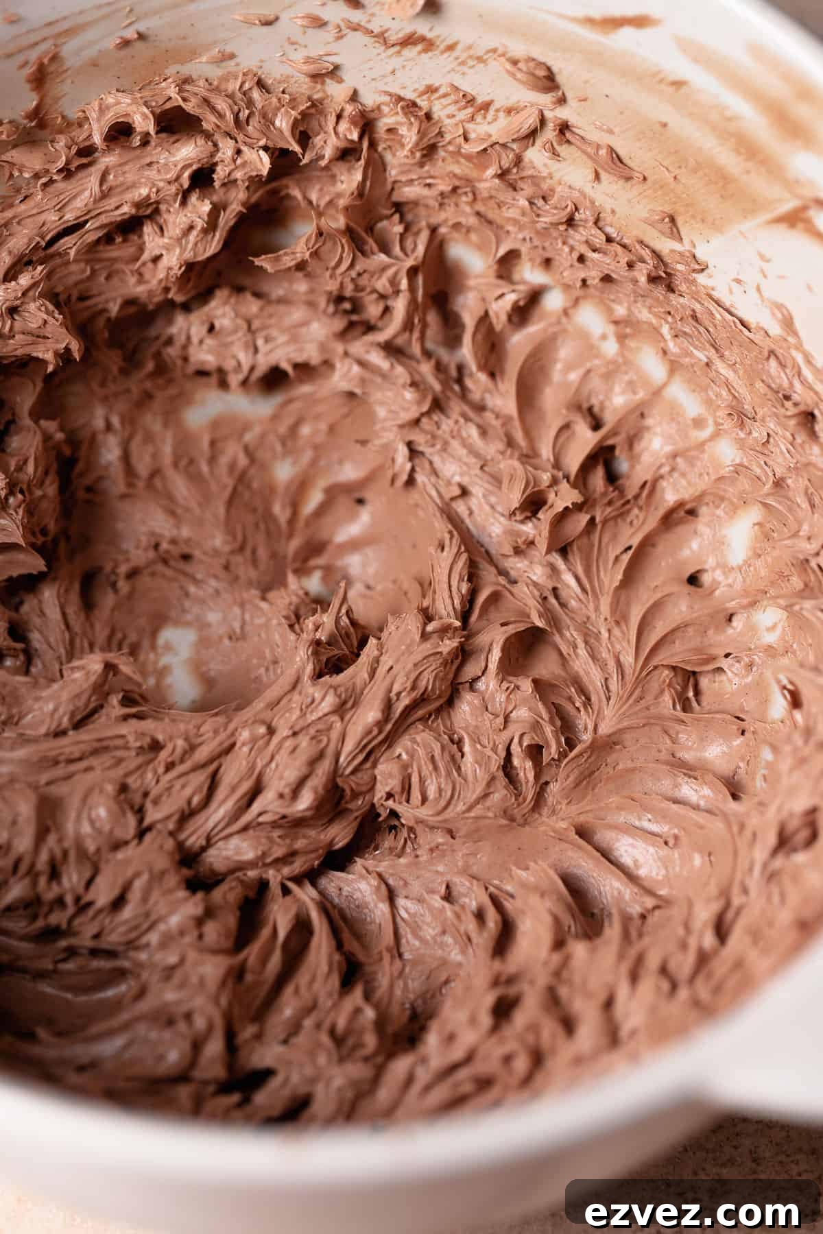 Fudgy Brown Butter Chocolate Brownie Cake Recipe 7 A mixing bowl with milk chocolate buttercream in it.
