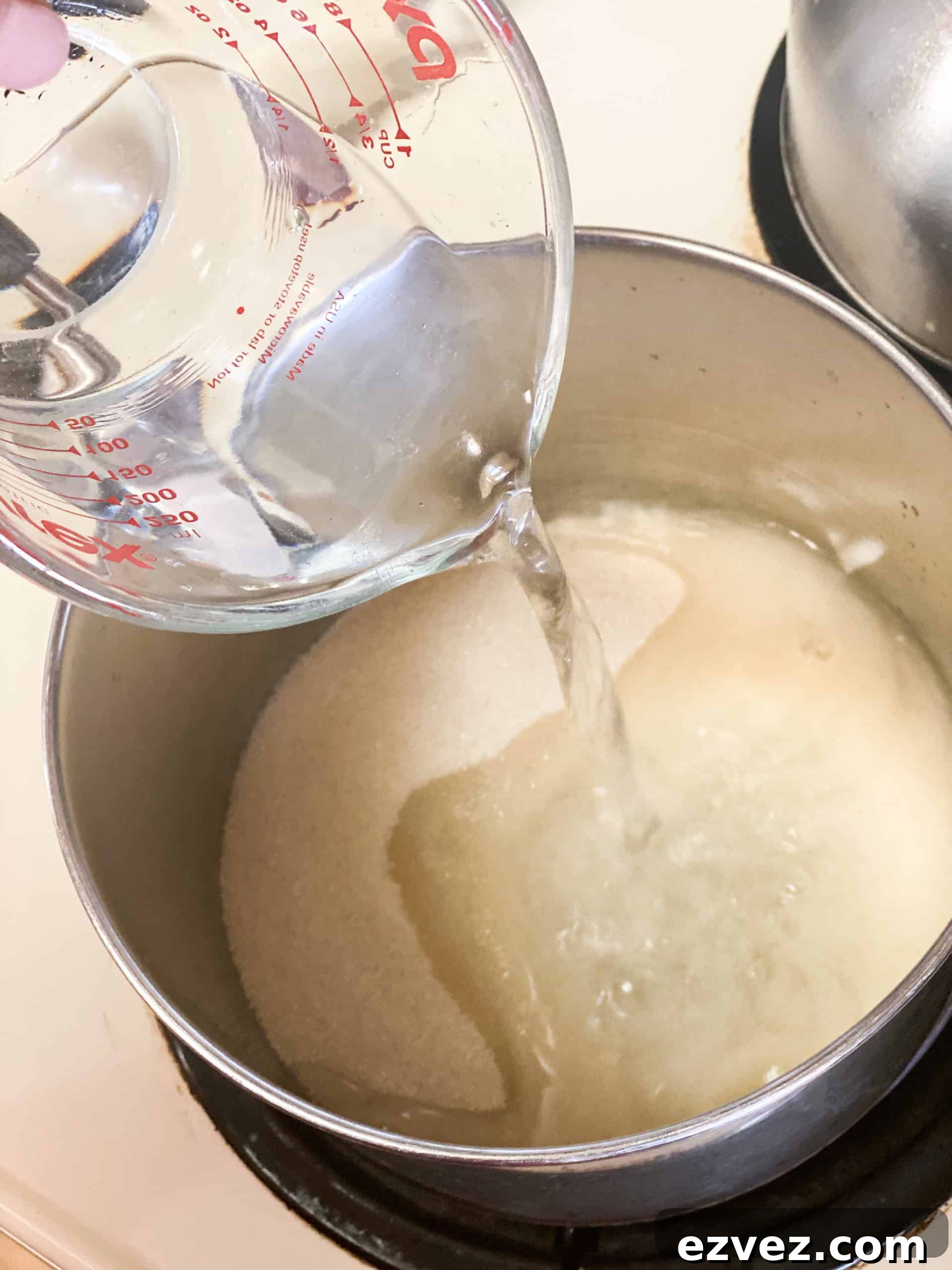Water added to sugar in a pot