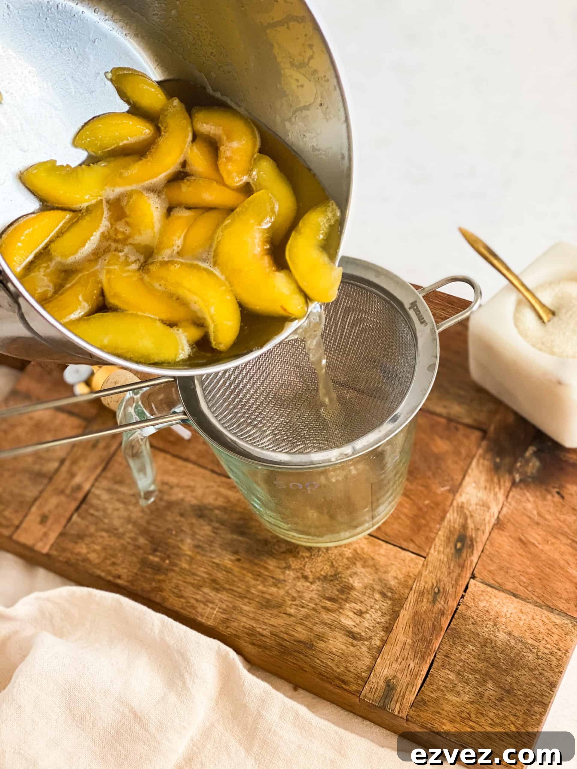 Peach Simple Syrup being poured into a strainer