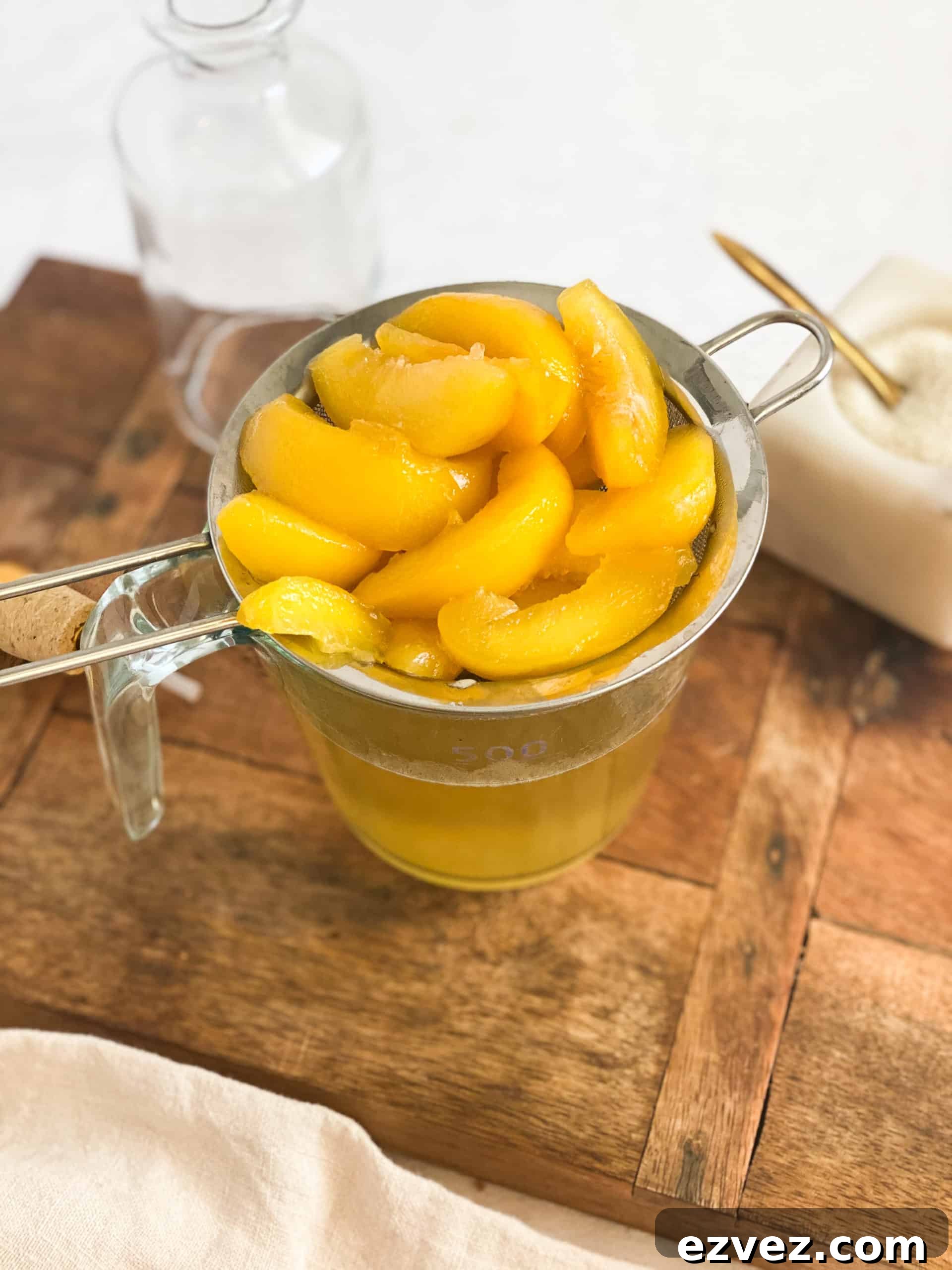 Peach Simple Syrup peaches in a strainer