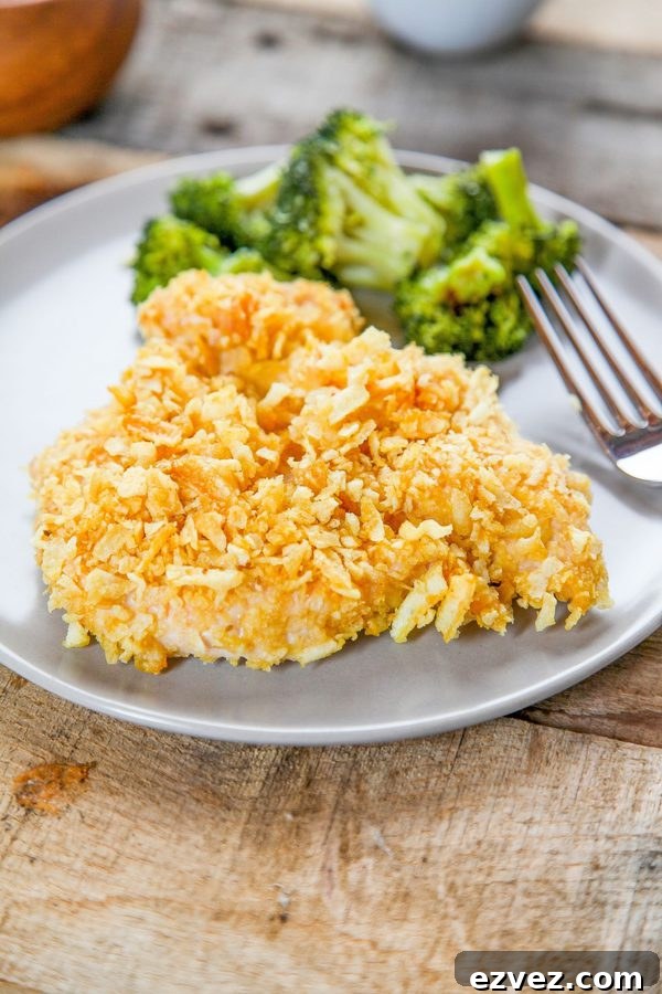 chicken coated in crushed potato chips with broccoli on a plate.