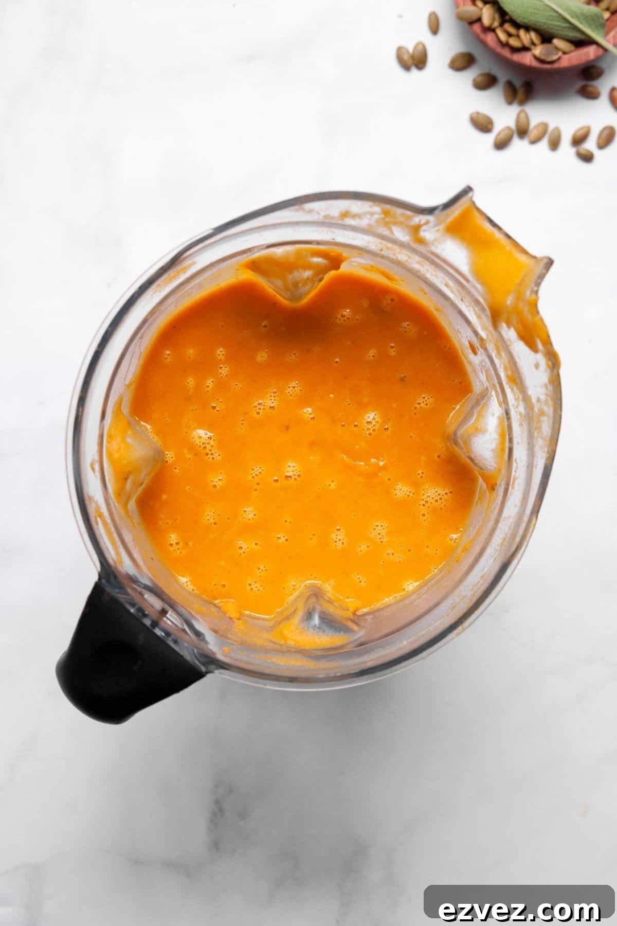 Blending sweet potato and pumpkin soup in a blender until silky smooth.
