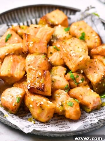 Air fryer salmon bites on a parchment-lined plate.