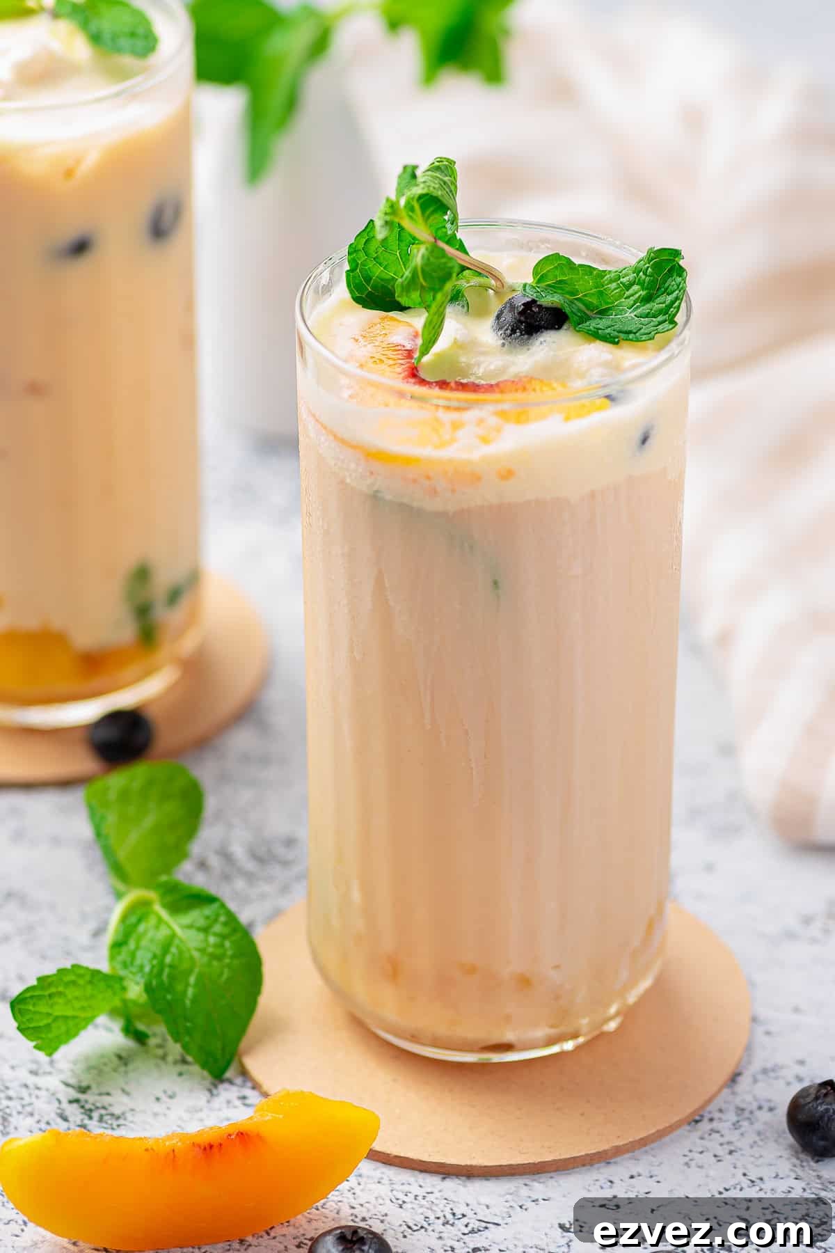 Creamy Peach Iced Tea Recipe: Smooth, Refreshing Summer Drink 2 Close up of Creamy Peach Tea in tall glass with garnishes.