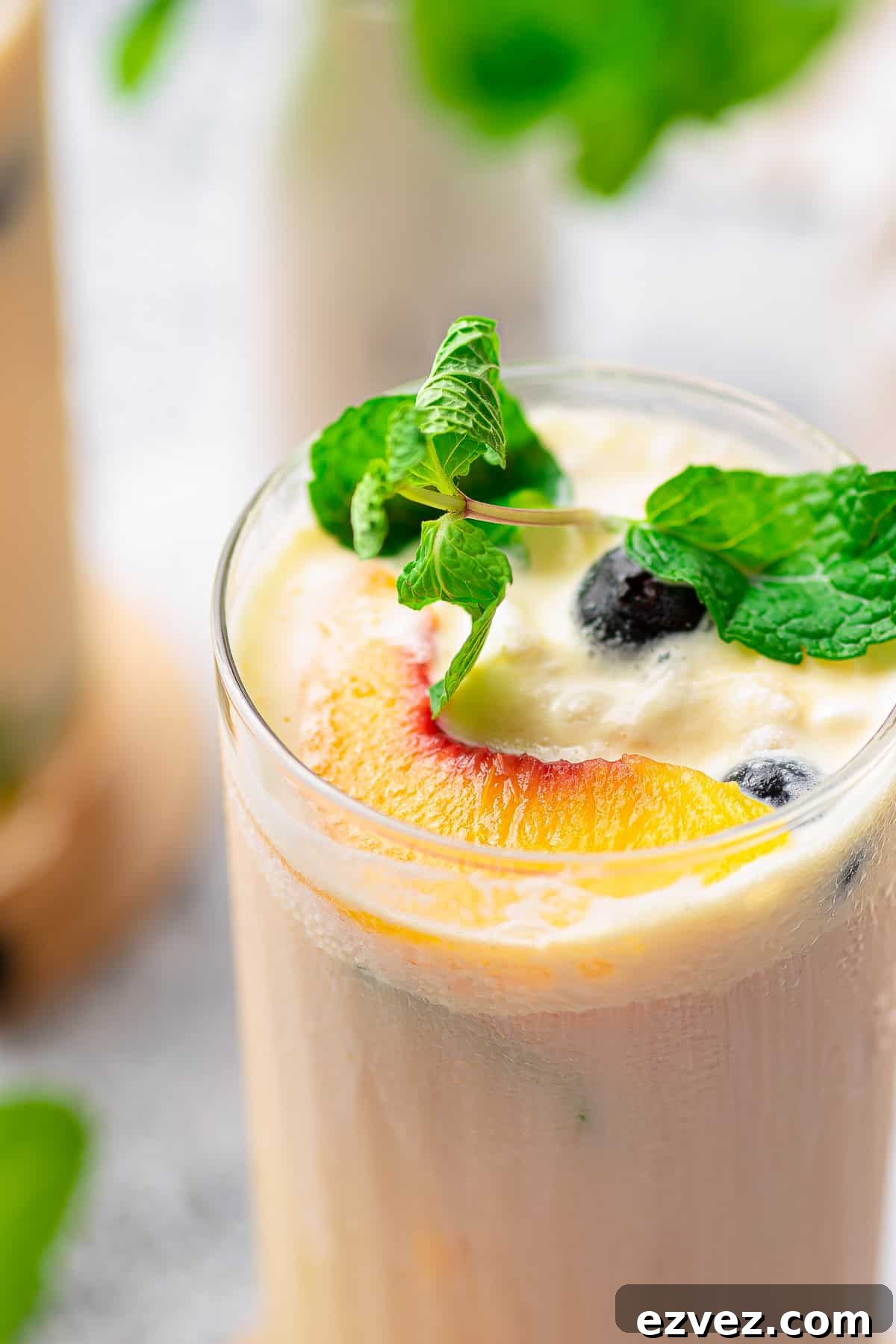 Creamy Peach Iced Tea Recipe: Smooth, Refreshing Summer Drink 3 Close up overhead of Creamy Peach Tea showing garnishes.