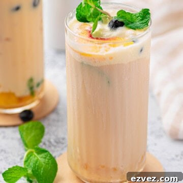 Creamy Peach Iced Tea Recipe: Smooth, Refreshing Summer Drink 8 Close up of Creamy Peach Tea in tall glass with garnishes.