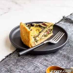 A slice of quiche with rainbow Swiss chard in it, served with a small bowl of salt on the side.