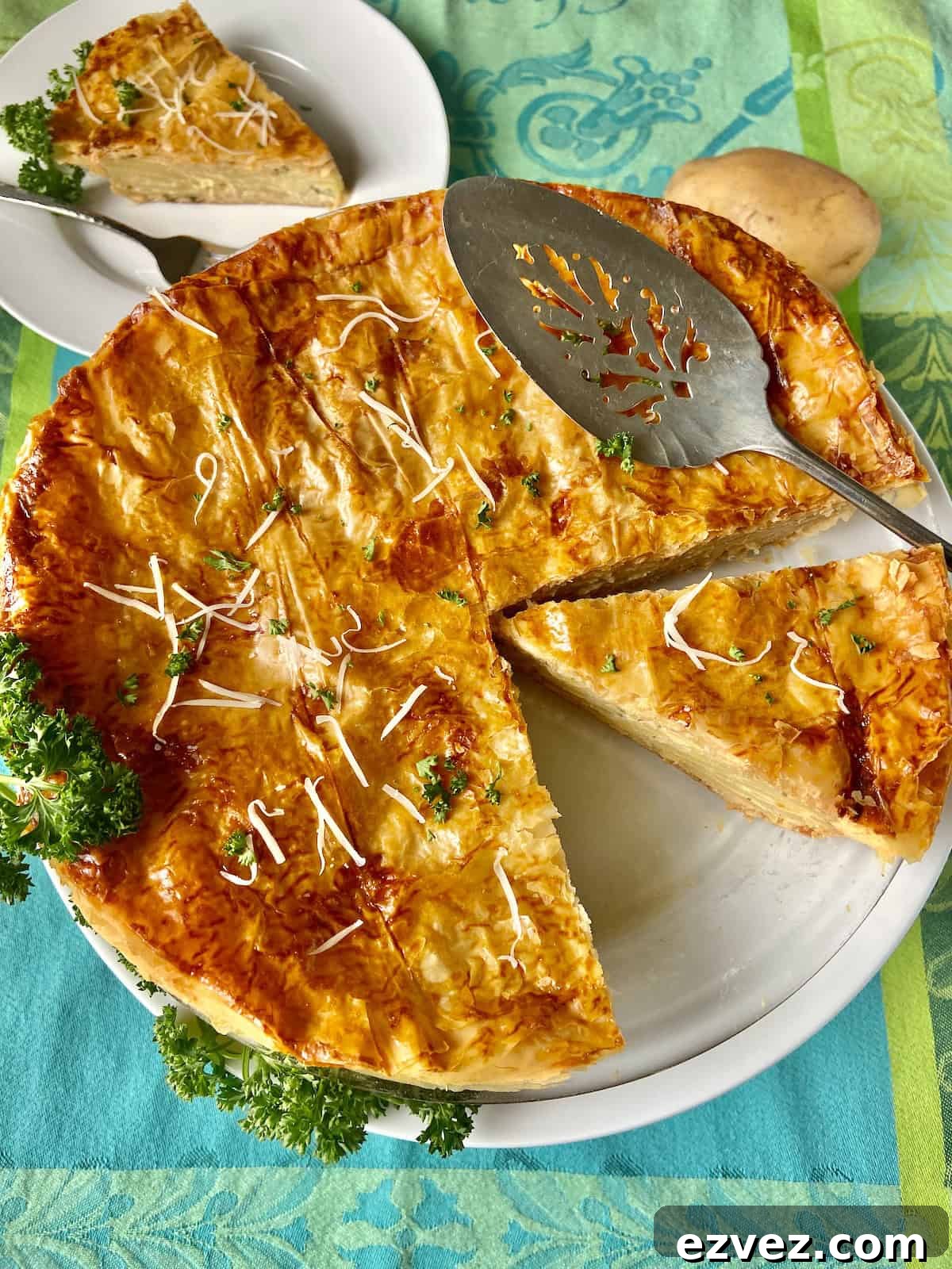 French potato pie in white pie plate with antique server.