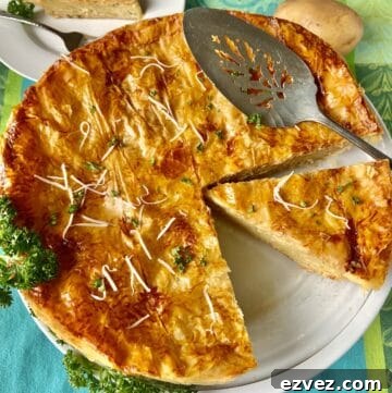 French Potato Pie in white pie plate with slotted server.