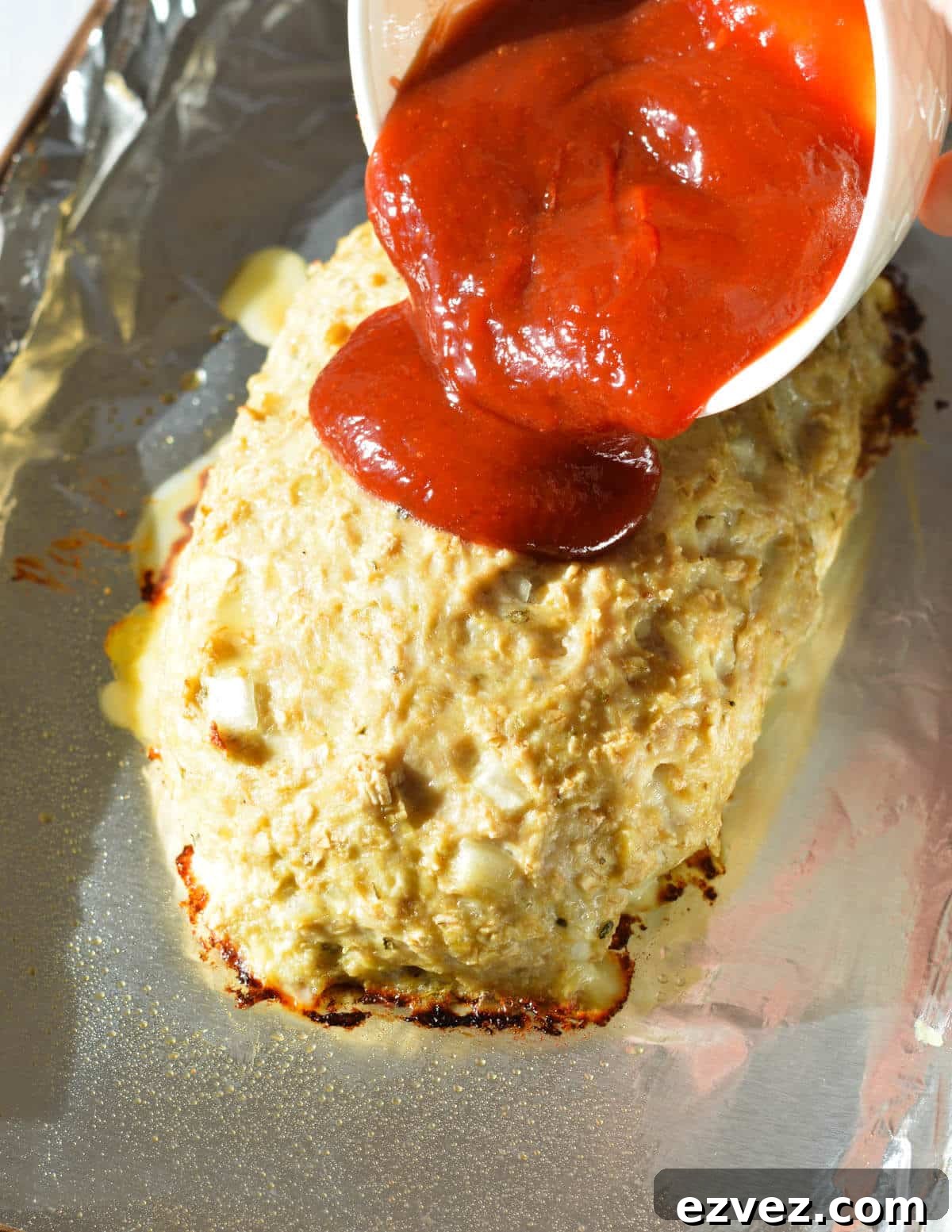 pouring the ketchup glaze onto a meatloaf. 