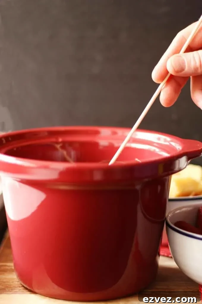 wooden skewer being dipped into chocolate fondue