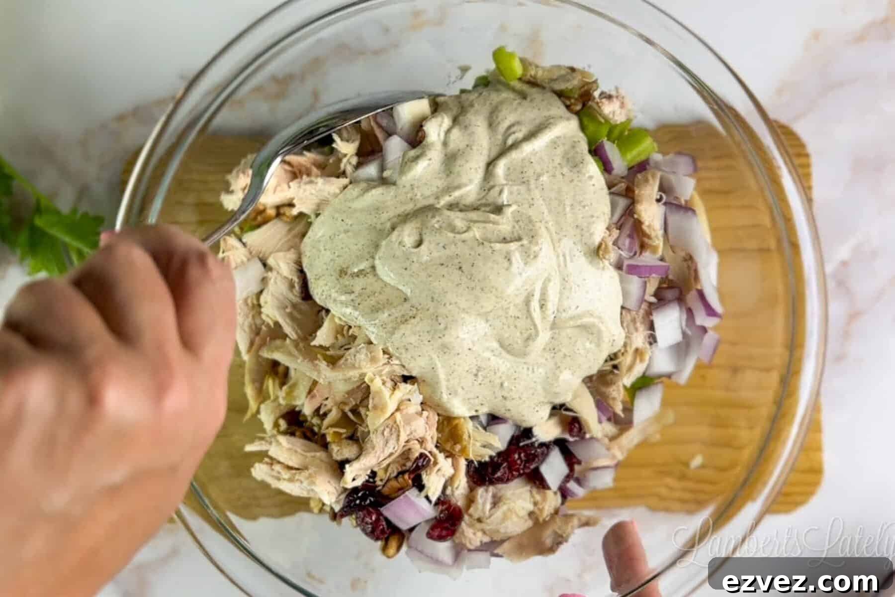adding dressing to chicken salad mixture.