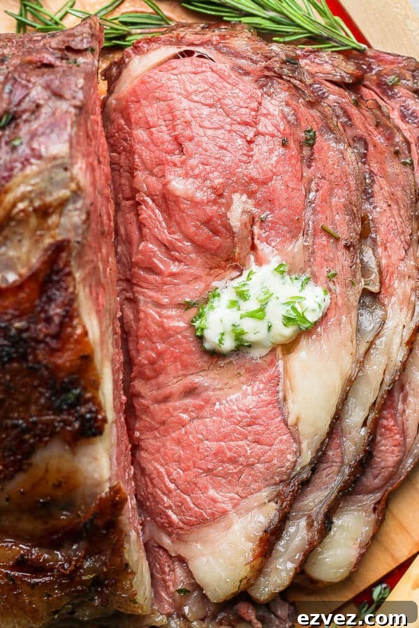 A medium-rare smoked prime rib on a cutting board with a dollop of herb butter.